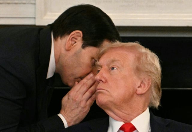 Le secrétaire d'Etat américain Marco Rubio chuchotte à l'oreille du président Donald Trump après lui avoir remis une note, lors d'une réunion à la Maison Blanche, le 8 octobre 2025 à Washington
