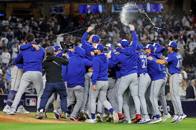 The Toronto Blue Jays celebrate after beating the New York Yankees to win their AL Division Series at Yankee Stadium.