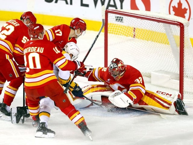Calgary Flames goalie Dustin Wolf battles the Nashville Predators' Gustav Nyquist in first-period NHL action at the Scotiabank Saddledome in this photo from Nov. 15, 2024.