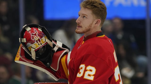 Mar 17, 2025; Toronto, Ontario, CAN; Calgary Flames goaltender Dustin Wolf (32) goes to put on his mask before a game against the Toronto Maple Leafs at Scotiabank Arena. Mandatory Credit: John E. Sokolowski-Imagn Images