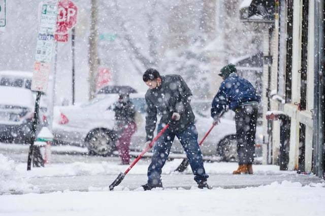 FILE - People clear a sidewalk during a winter snowstorm in Philadelphia, Feb. 13, 2024. (AP Photo/Matt Rourke, File)