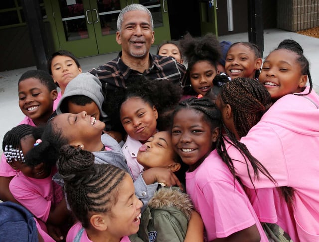 Collective Impact Executive Director James Spingola poses with children outside the Ella Hill Hutch Community Center, in 2018. On Thursday an administrative judge ruled in the nonprofit's favor in a city probe into allegations of conflict of interest.