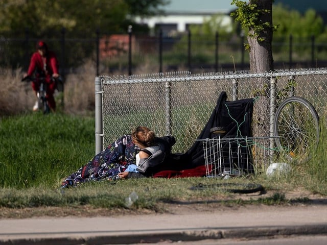An unhoused person is camped out by the train track across from Station 20 West in Saskatoon.