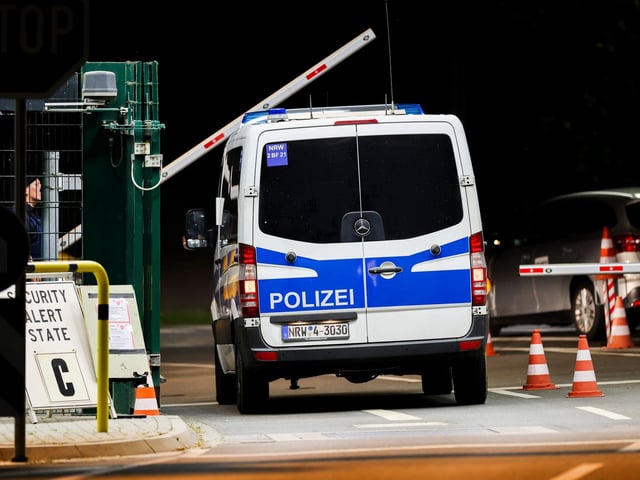 Ein Mannschaftswagen der Polizei fährt auf das militärische Gelände am Nato-Stützpunkt Geilenkirchen