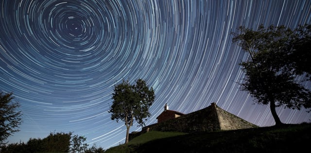 -FOTODELDIA- GRAF6758. COMILLAS (ESPAÑA), 08/10/2019.- Imagen de larga exposición que muestra las estrellas circumpolares sobre la ermita de San Esteban, en Comillas (España), en la madrugada de este martes, coincidiendo con las dracónidas, las primera lluvia de estrellas del otoño. EFE/ Pedro Puente Hoyos