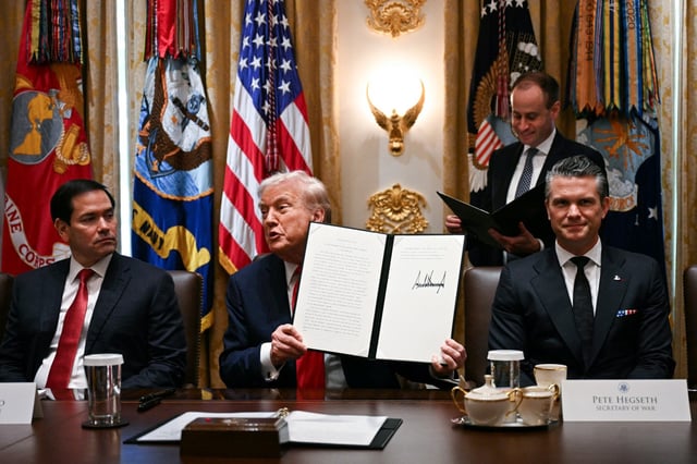 President Donald Trump (C) holds up signing documents recognizing days honoring Leif Erikson and Christopher Columbus while he speaks during a cabinet meeting, alongside Secretary of State Marco Rubio (L) and Secretary of Defense Pete Hegseth (R), in the Cabinet Room of the White House in Washington, DC, on October 9, 2025. (Photo by JIM WATSON/AFP via Getty Images)
