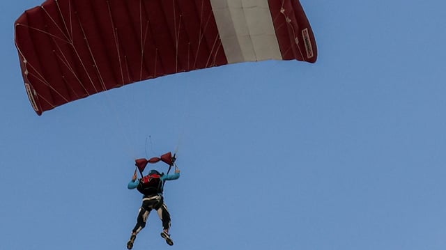 A skydiver steers their parachute.