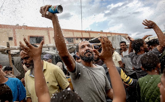 Internally displaced Palestinians celebrate the announcement of a ceasefire agreement between Hamas and Israel in Khan Younis, southern Gaza Strip, 9 October 2025. (Photo: EPA / Haitham Imad)