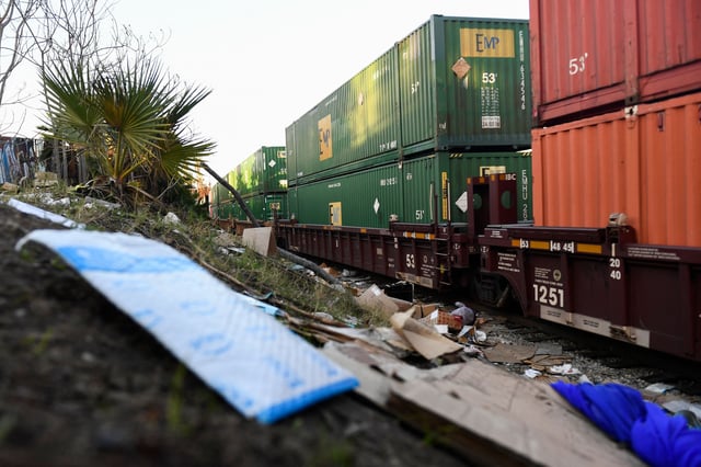 An Amazon Prime package (L) rests on a hillside as a train passes through a section of Union Pacific train tracks littered with thousands of opened boxes and packages stolen from cargo shipping containers, targeted by thieves as the trains stop in downtown Los Angeles, California on January 14, 2022. – Dozens of freight cars are broken into every day in Los Angeles by thieves who take advantage of their stops to loot the packages they carry, leaving thousands of stale boxes and internet-bought goods on the tracks that will never reach their destination.
According to the labels found Friday by a team of AFP on a track near downtown, easily accessible from nearby streets, most of the major U.S. mail order and courier companies (Amazon, Target, UPS, Fedex, etc.) were affected by these thefts that have exploded in recent months. (Photo by Patrick T. FALLON / AFP) (Photo by PATRICK T. FALLON/AFP via Getty Images)