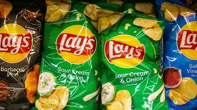Bags of Lay's potato chips at a grocery store.