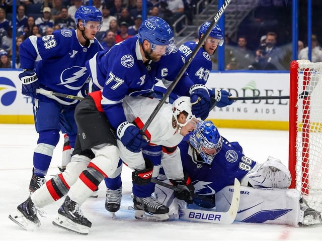 Victor Hedman #77 of the Tampa Bay Lightning defends against Ridly Greig #of the Ottawa Senators as Andrei Vasilevskiy #88 makes a save during the first period in Tampa on Thursday.
