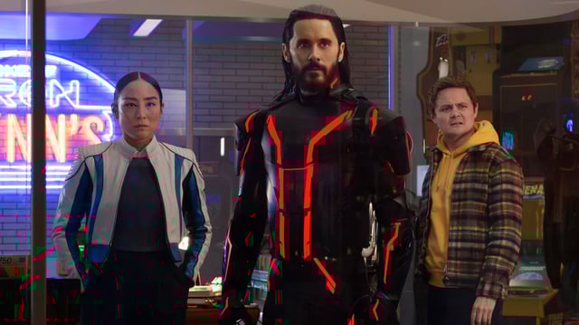 L-R: Eve Kim (Greta Lee), Ares (Jared Leto) and Seth (Arturo Castro) in a scene from Disney's "TRON: Ares"