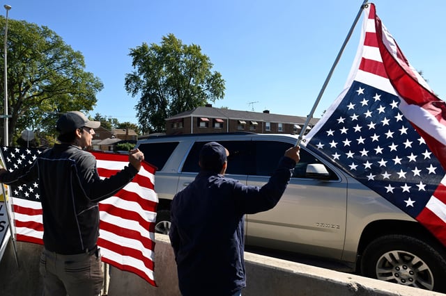 Protestors yell at Immigration and Customs Enforcement agents driving out of an immigration processing facility in Broadview, Ill., Thursday, Oct. 9, 2025. (AP Photo/Paul Beaty)
