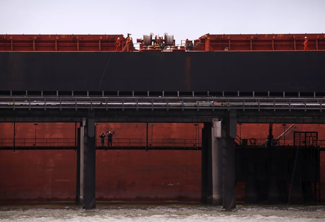 Port workers load a ship with coal at the RG Tanna Coal Terminal located at the town of Gladstone in Queensland, Australia, June 12, 2015.   REUTERS/David Gray/File Photo