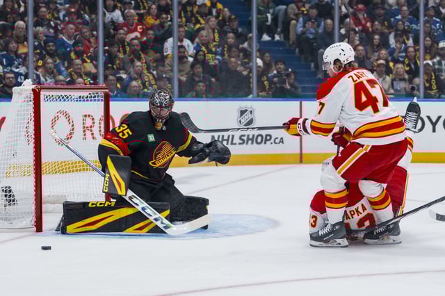 Oct 9, 2025; Vancouver, British Columbia, CAN; Vancouver Canucks goalie Thatcher Demko (35) makes a save on Calgary Flames forward Connor Zary (47) in the first period at Rogers Arena. Mandatory Credit: Bob Frid-Imagn Images