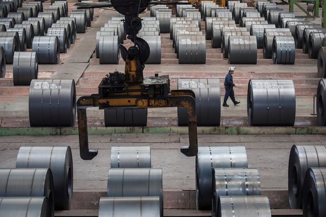 A worker walks past steel rolls at the Chongqing iron and steel plant in Changshou, Chongqing, China, August 6, 2018. REUTERS/Damir Sagolj/File Photo