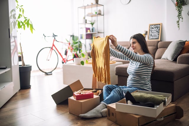 Young woman unboxing online purchases in living room