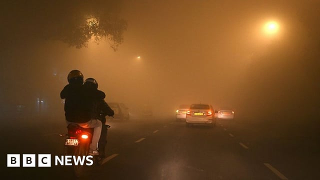 Vehicles travel through dense fog on a cold winter morning in New Delhi on December 27, 2023