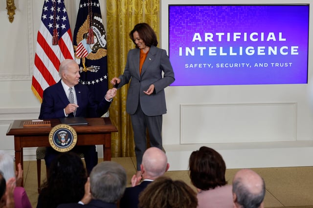U.S. President Joe Biden hands Vice President Kamala Harris the pen he used to sign a new executive order regarding artificial intelligence during an event in the East Room of the White House on October 30, 2023 in Washington, DC. President Biden issued the executive order directing his administration to create a new chief AI officer, track companies developing the most powerful AI systems, adopt stronger privacy policies and "both deploy AI and guard against its possible bias," creating new safety guidelines and industry standards. (Photo by Chip Somodevilla/Getty Images)
