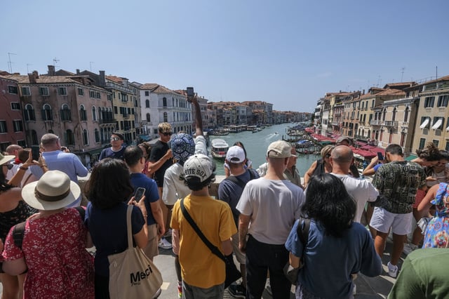 Tourists flock to the Rialto Bridge in Venice in August.