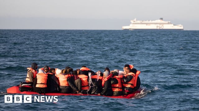 Migrants packed tightly onto a small inflatable boat attempt to cross the English Channel near the Dover Strait