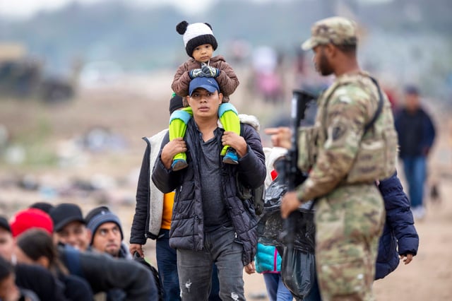 A Texas National Guard soldier counts a group of immigrants at the U.S.-Mexico border in Eagle Pass, Texas on Dec. 20, 2023.