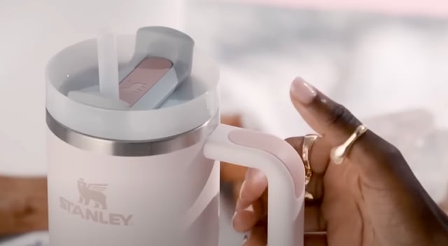 hand reaching for stanley cup tumbler