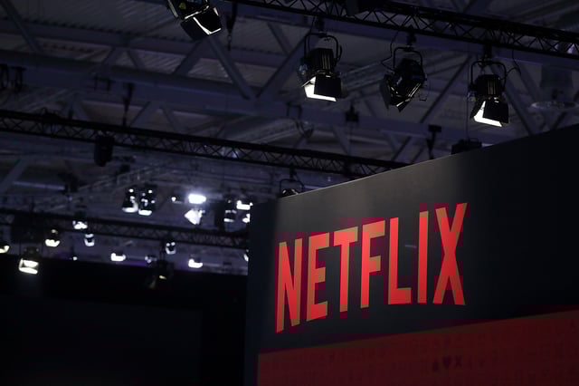 A Netflix Inc. logo sits on the online television streaming company's exhibition area at the Gamescom gaming industry event in Cologne, Germany