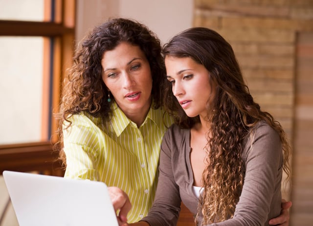 mother and daughter using laptop together