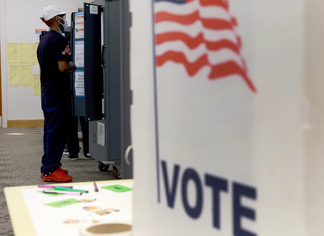 Demetrick Favors fills out his ballot at a voting machine as he votes in the Georgia primary at the Metropolitan Library on May 24, 2022 in Atlanta, Georgia.