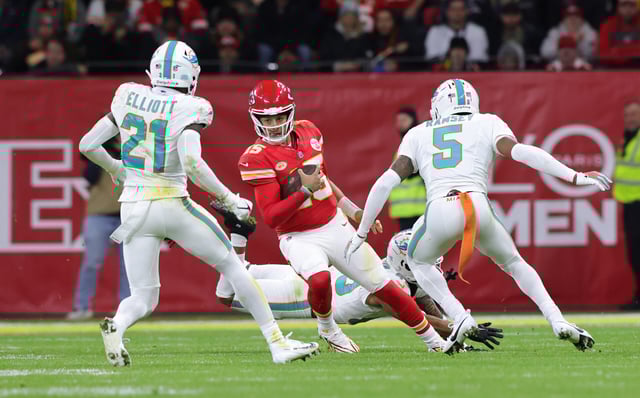 Quarterback Patrick Mahomes of Kansas City Chiefs (C) and DeShon Elliott of Miami Dolphins and teammate Jalen Ramsey compete for the ball during the NFL match between Miami Dolphins and Kansas City Chiefs at Deutsche Bank Park on November 5, 2023 in Frankfurt am Main, Germany.