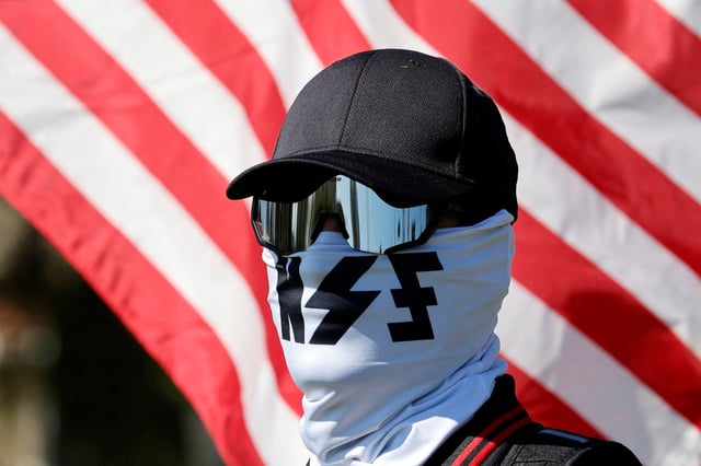 A member of the white nationalist group NatSoc Florida protests against U.S. support for Israel, in response to the war between Israel and Hamas, in Lady Lake, Fla., on Oct. 21, 2023. 
