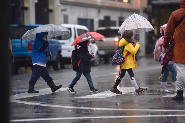 FILE - School children walk with umbrellas in downtown San Francisco during heavy rain, Wednesday Dec. 20, 2023.