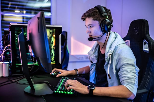 Someone playing video games on a PC (Photo by ELLA DON on Unsplash)