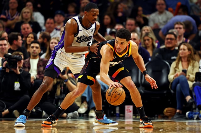 Phoenix Suns guard Devin Booker (1) handles the ball against Sacramento Kings guard De'Aaron Fox (5) during the third quarter at Footprint Center in Phoenix on Jan. 16, 2024.