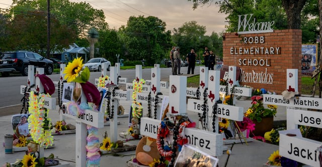 Law enforcement stand watch on May 24, 2023, near a memorial dedicated to the 19 children and two adults murdered a year earlier during a mass shooting at Robb Elementary School in Uvalde, Texas. (Photo: Brandon Bell/Getty Images)