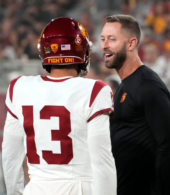 The former Arizona Cardinals head coach and now USC Trojans assistant coach Kliff Kingsbury talks to quarterback Caleb Williams (13) during the pregame warmup before playing the Arizona State Sun Devils at Mountain America Stadium in Tempe on Sept. 23, 2023.