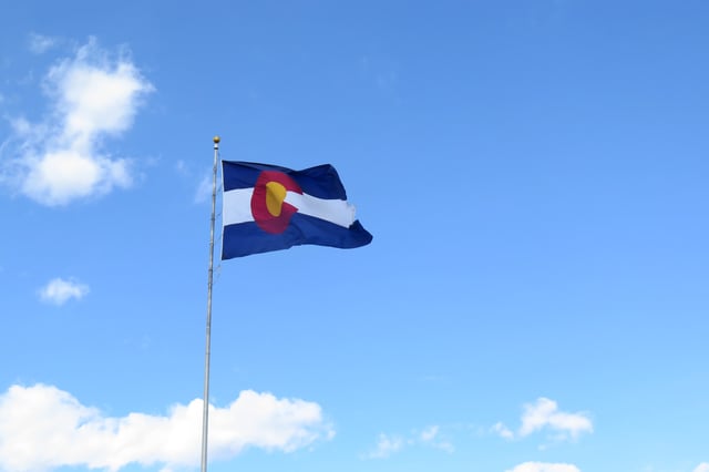 Colorado Flag waving in the wind against a Blue sky