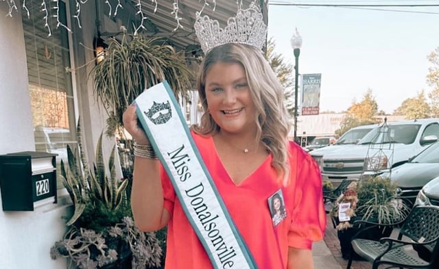 Trinity Poague holding her pageant sash