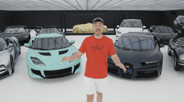 A screenshot of the video that earned MrBeast over $250k on X. The youtuber MrBeast stands in from of a showroom of supercars.
