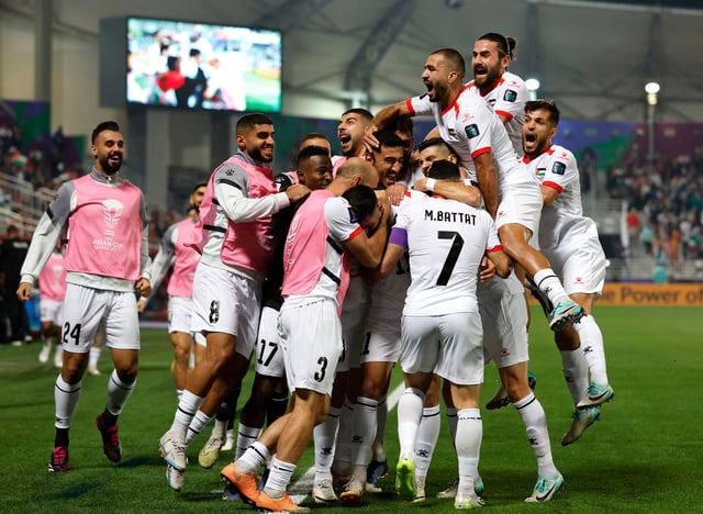 The Palestinian national team celebrates scoring their first goal with teammates in their Group C match against Hong Kong at the Abdullah bin Khalifa Stadium, Doha, Qatar on January 23, 2024.