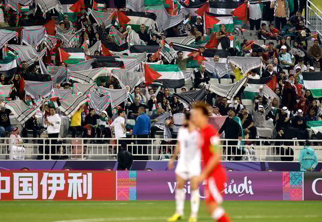 Fans react in the stands during the Palestine v Hong Kong match in Qatar.