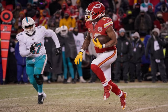 Jan 13, 2024; Kansas City, Missouri, USA; Kansas City Chiefs running back Isiah Pacheco (10) runs the ball as Miami Dolphins linebacker Malik Reed (47) chases in a 2024 AFC wild card game at GEHA Field at Arrowhead Stadium.