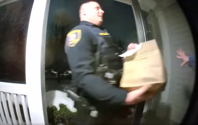 A sheriff's deputy completes a food delivery order after arresting the driver in Kane County, Ill. 