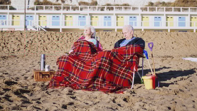 Old couple asleep on the beach