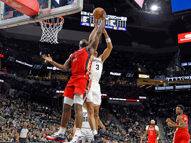The Spurs' Keldnon Johnson, right, battles the Pelicans' Zion Williamson for a rebound during a Dec. 17, 2023 game at Frost Bank Center.