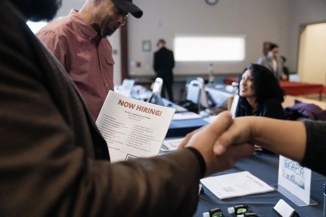 Attendees shake hands at a Veteran Employment and Resource Fair in Long Beach, California, US, on Tuesday, Jan. 9, 2024.
