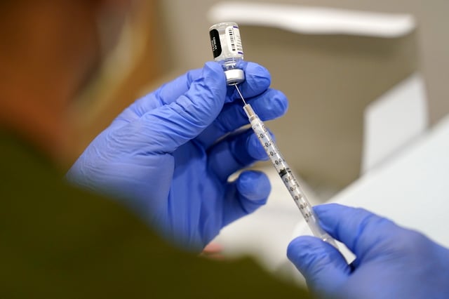 FILE - A healthcare worker fills a syringe with the Pfizer COVID-19 vaccine at Jackson Memorial Hospital on Oct. 5, 2021, in Miami. Lawyers for a group of Navy SEALS and other Navy personnel who oppose a COVID-19 vaccination requirement on religious grounds want a federal appeals court to keep alive their legal fight against the Biden administration, even though the requirement has been lifted. (AP Photo/Lynne Sladky, File)