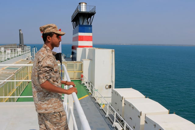 A picture taken during an organized tour by Yemen's Huthi rebels on November 22, 2023 shows a security guard aboard the Galaxy Leader cargo ship, seized by Huthi fighters two days earlier, in a port on the Red Sea. The ship, operated by a Japanese firm but having links to an Israeli businessman, was headed from Turkey to India when it was seized and re-routed.