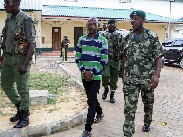 Self-proclaimed pastor Paul Nthenge Mackenzie (C) walks surrounded by Kenya Police Officers as he appears at the Shanzu Law Courts in Mombasa on January 18, 2024. A Kenyan court on January 18, 2024 charged the leader of a starvation cult with terrorism over the deaths of more than 400 of his followers. Paul Nthenge Mackenzie is alleged to have incited his acolytes to starve to death in order to "meet Jesus" in a case that shocked the world. (Photo by AFP) (Photo by -/AFP via Getty Images)